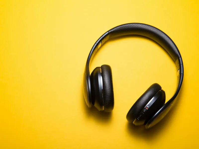 Headphones photographed against a warm yellow background